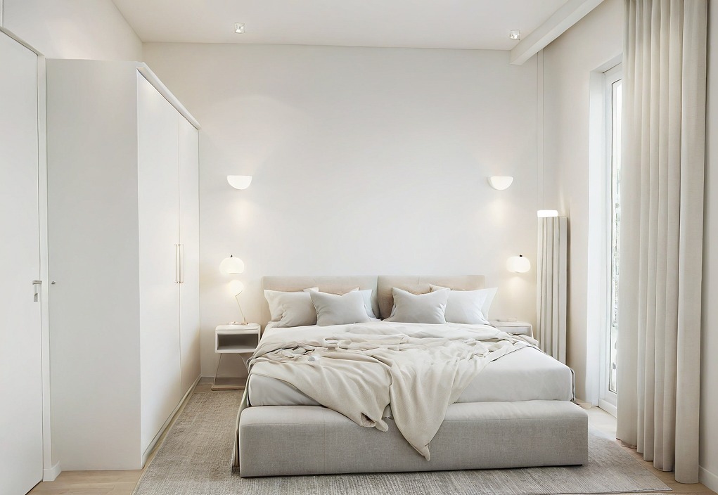 Jasna sypialnia w minimalistycznym stylu: duże łóżko z beżową narzutą, białe szafki nocne i lampki, białe ściany z półokrągłymi kinkietami, wysokie okno z zasłoną.