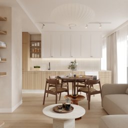 Tomasz Marek Architekt - Jasne, przestronne wnętrze z drewnianymi akcentami: okrągły stół, krzesła, sofa i półki z książkami, oświetlone naturalnym światłem wpadającym przez okno.