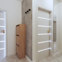 Nowoczesny przedpokój: drewniana szafka na buty, białe drzwi z podświetleniem, betonowa ściana z trzema czarnymi wieszakami, lustro i podłoga w terazzo.