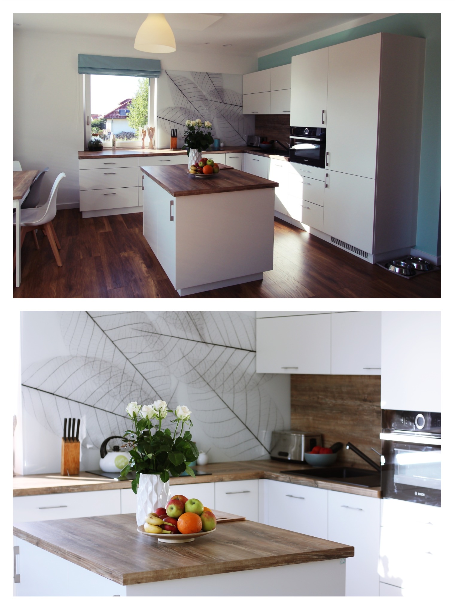 Nowoczesna kuchnia z wyspą w Bulowicach. Białe szafki, drewniany blat, okno z roletą rzymską i dekoracyjna tapeta z motywem liści. Jasne, przestronne wnętrze.