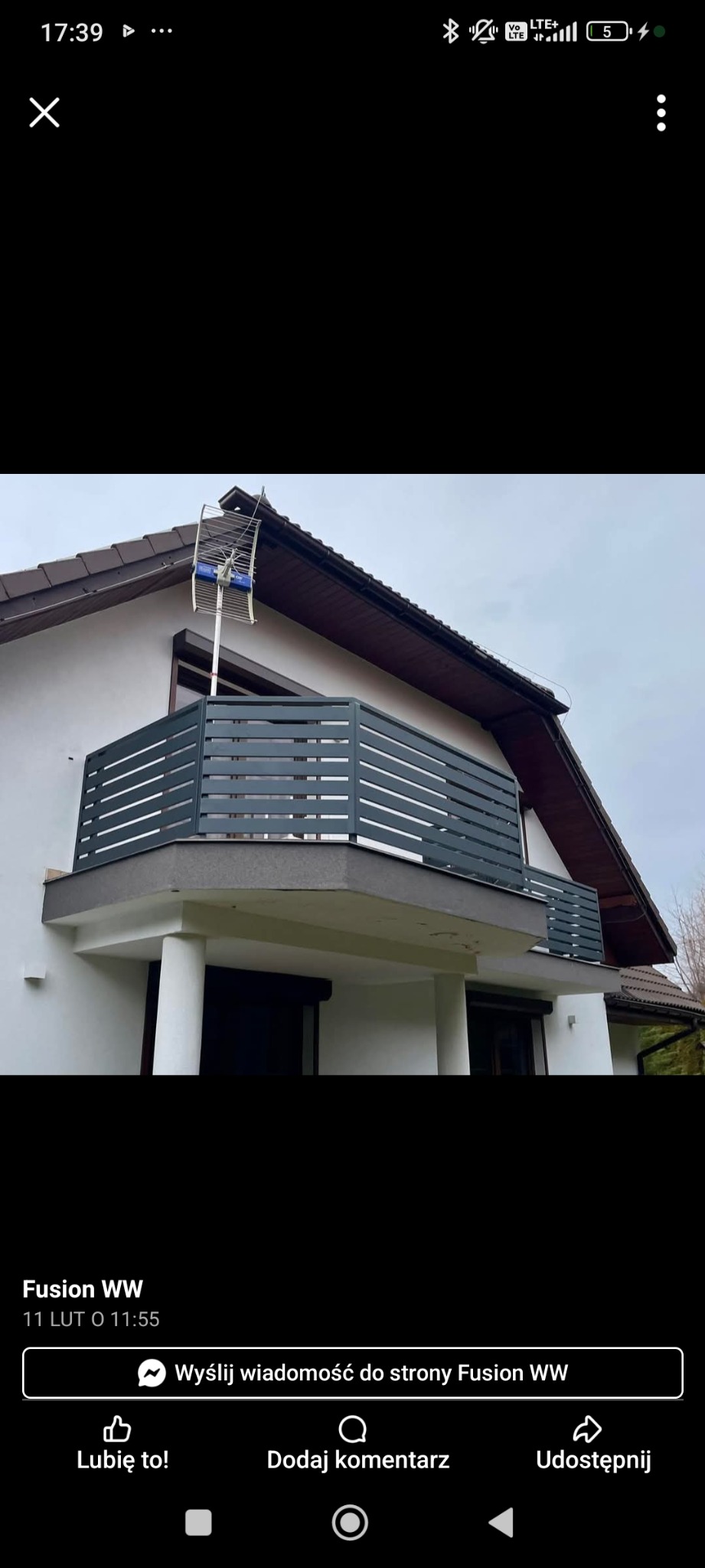 Nowoczesna zabudowa balkonu z poziomymi panelami w Ogrodzieńcu. Szara konstrukcja idealnie komponuje się z elewacją domu, a na dachu widoczna antena.