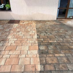 Pod Ciśnieniem - Kostka brukowa przed i po czyszczeniu, widoczna różnica w kolorze i czystości. Część powierzchni wyczyszczona, druga zabrudzona. Budynek w tle.