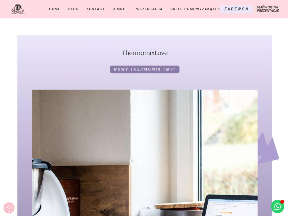 Strona internetowa ThermomixLove z informacją o nowym Thermomix TM7, widoczny mikser kuchenny i laptop na tle okna, w tle elementy drewniane.