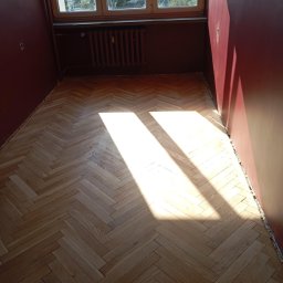 Parkiet dębowy po fazie cyklinowania i podczas schnięcia pierwszej warstwy lakieru specjalistycznego na bazie hydro z dodatkiem utwardzacza. Wykończenie bezbarwny pół mat. 