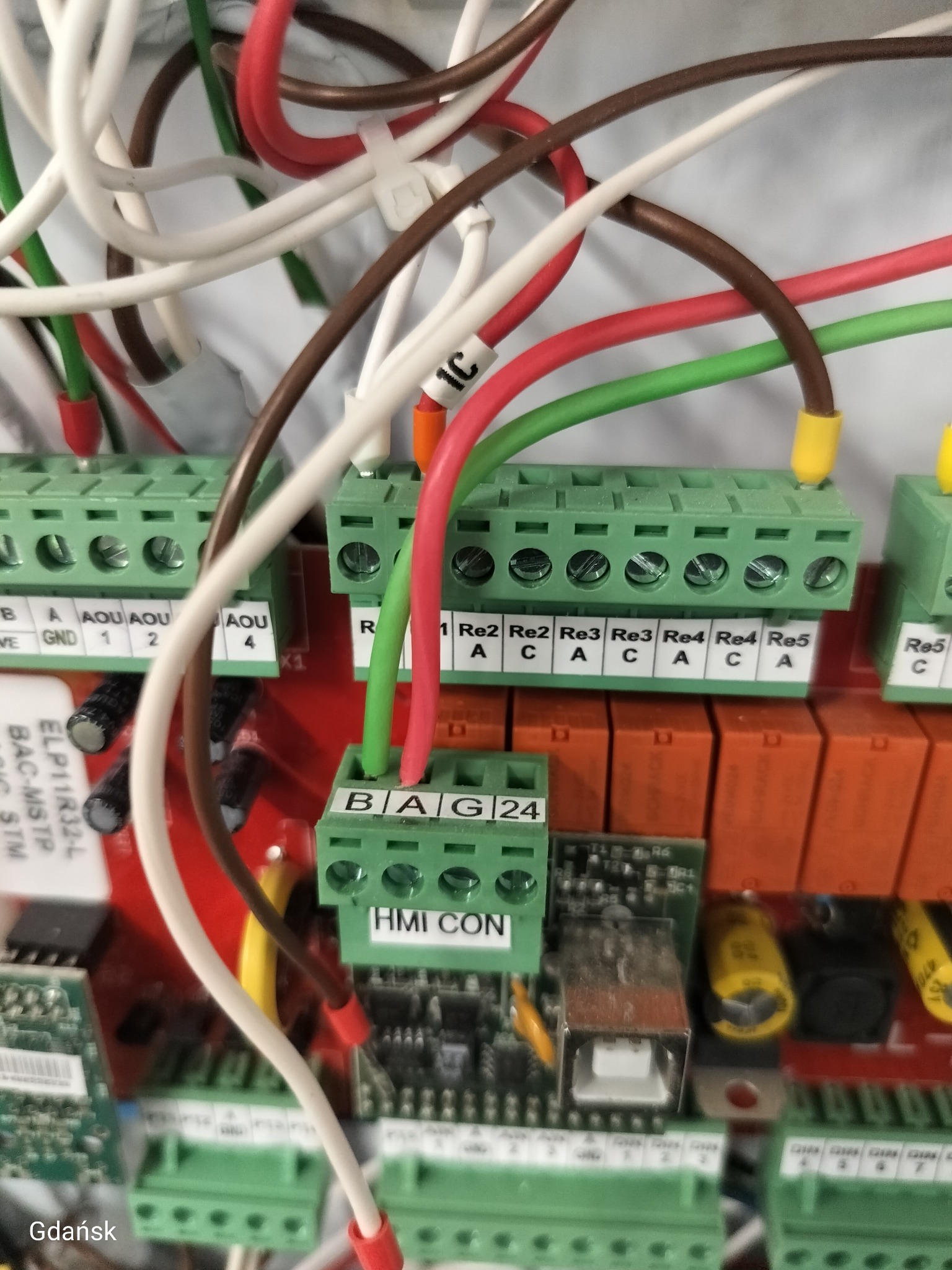 Panel sterowania z przewodami i złączkami w kolorach: białym, czerwonym, zielonym, brązowym i żółtym. Usługa elektryczna w Gdańsku.