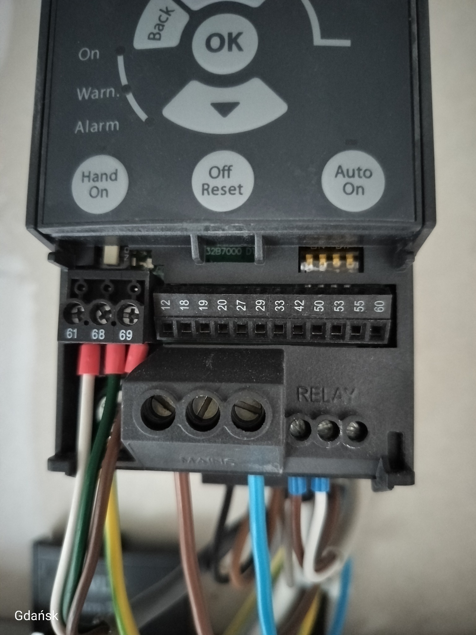 Szczegółowe ujęcie panelu sterowania z podłączonymi przewodami, widoczne złącza i oznaczenia. Panel w szarej obudowie z napisem 'RELAY'.