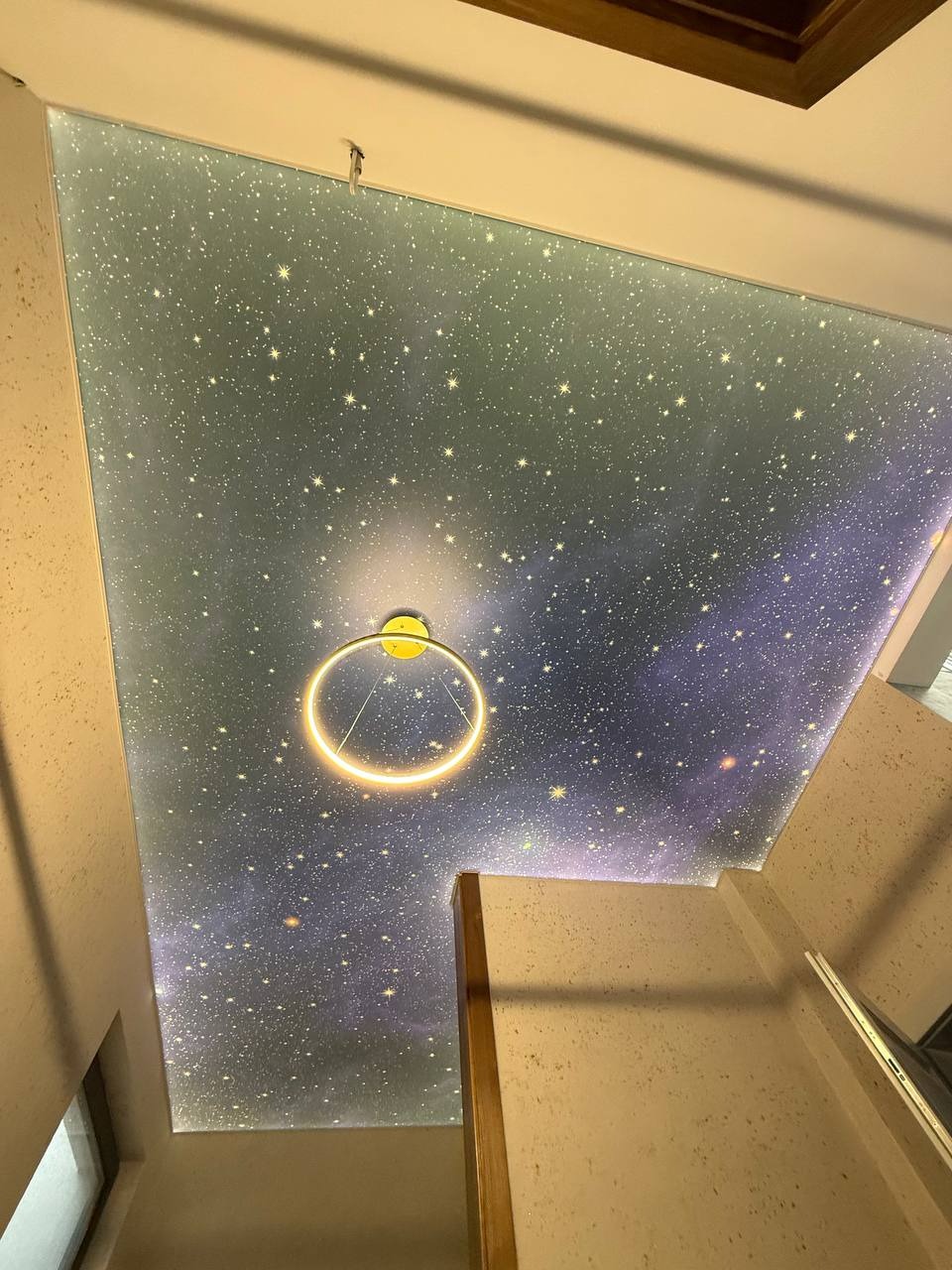 Gwieździste niebo na suficie z okrągłą lampą LED. Dekoracyjny sufit z motywem kosmosu, oświetlenie punktowe. Wykończenie wnętrza z efektem wizualnym.