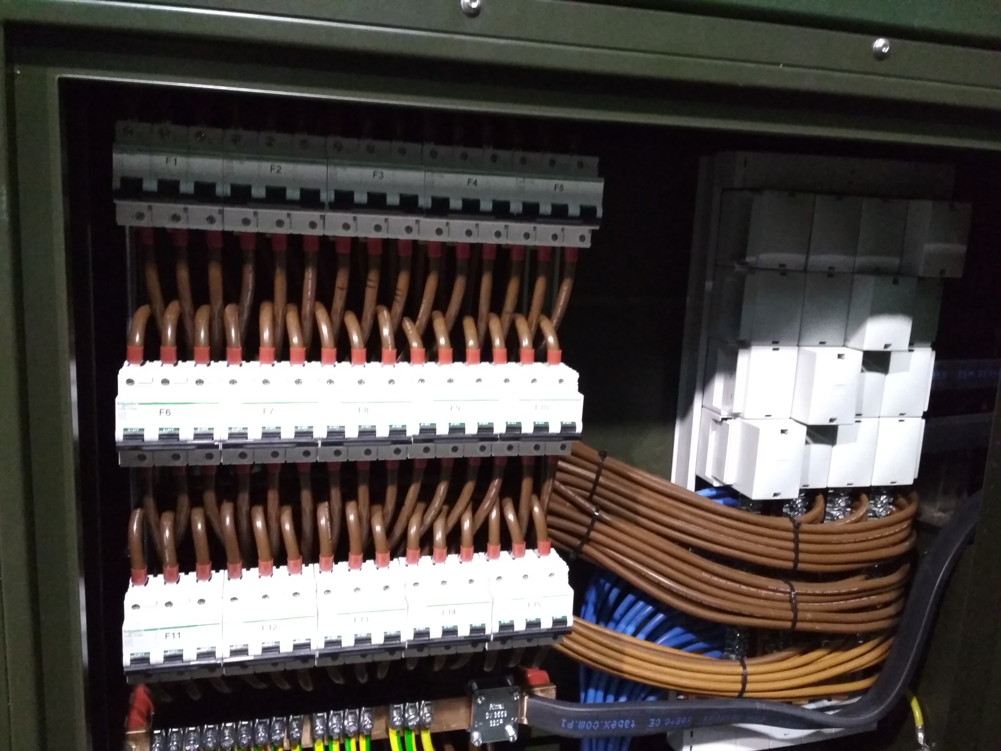 Rozdzielnica elektryczna z przewodami w Lubzinie. Widoczne bezpieczniki, kable brązowe i niebieskie. Estetyczny montaż w szafie sterowniczej.