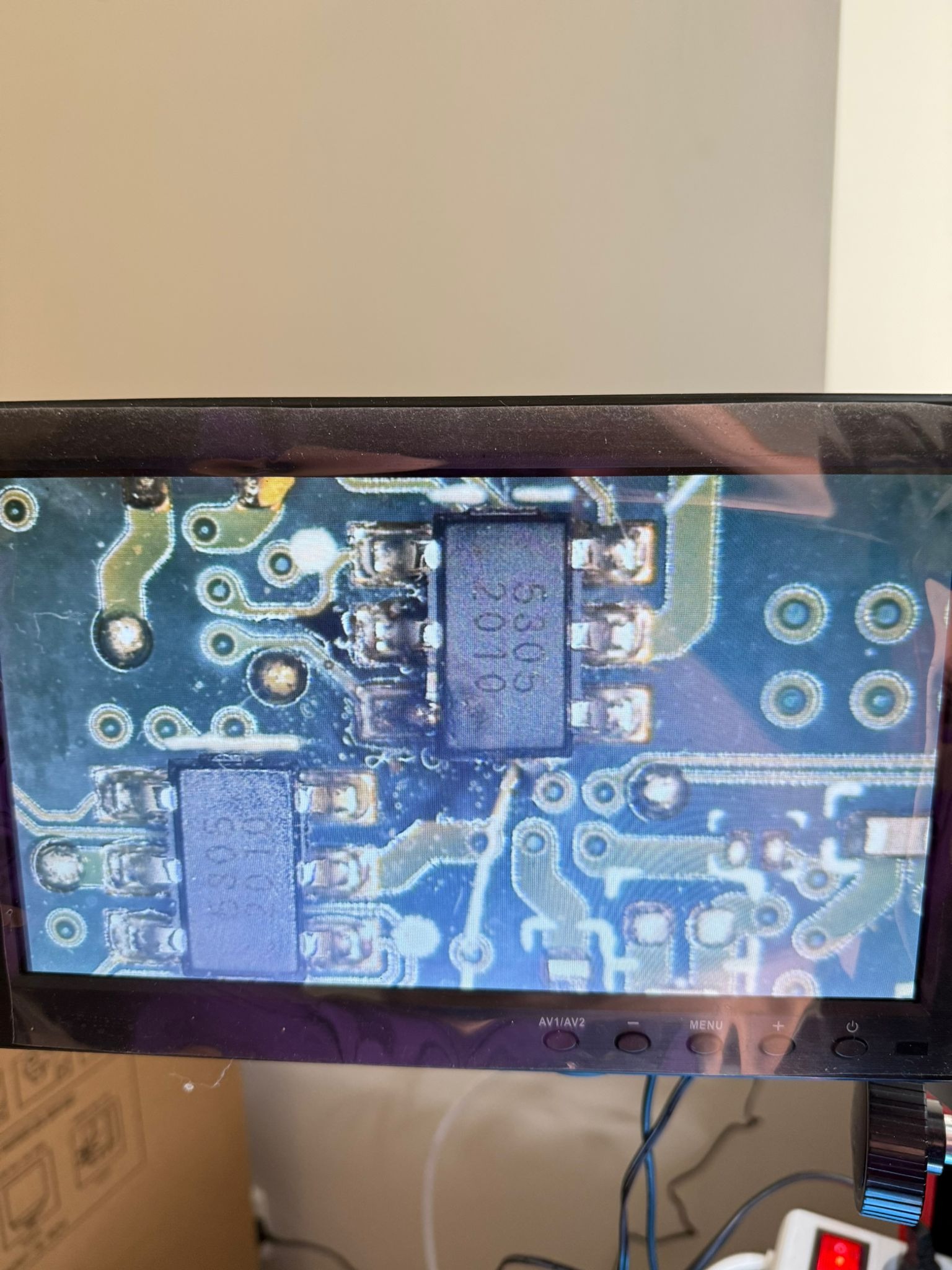 Ekstremalne zbliżenie na płytkę drukowaną pod mikroskopem, widoczne elementy elektroniczne i ścieżki. Detaliczna inspekcja i analiza obwodu.