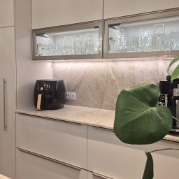 Blat i ściana z naturalnego kwarcytu Taj Mahal nadają kuchni elegancji i lekkości. Kamień ten pięknie komponuje się z jasną zabudową, a jego subtelne żyłkowanie dodaje wnętrzu klasy premium.