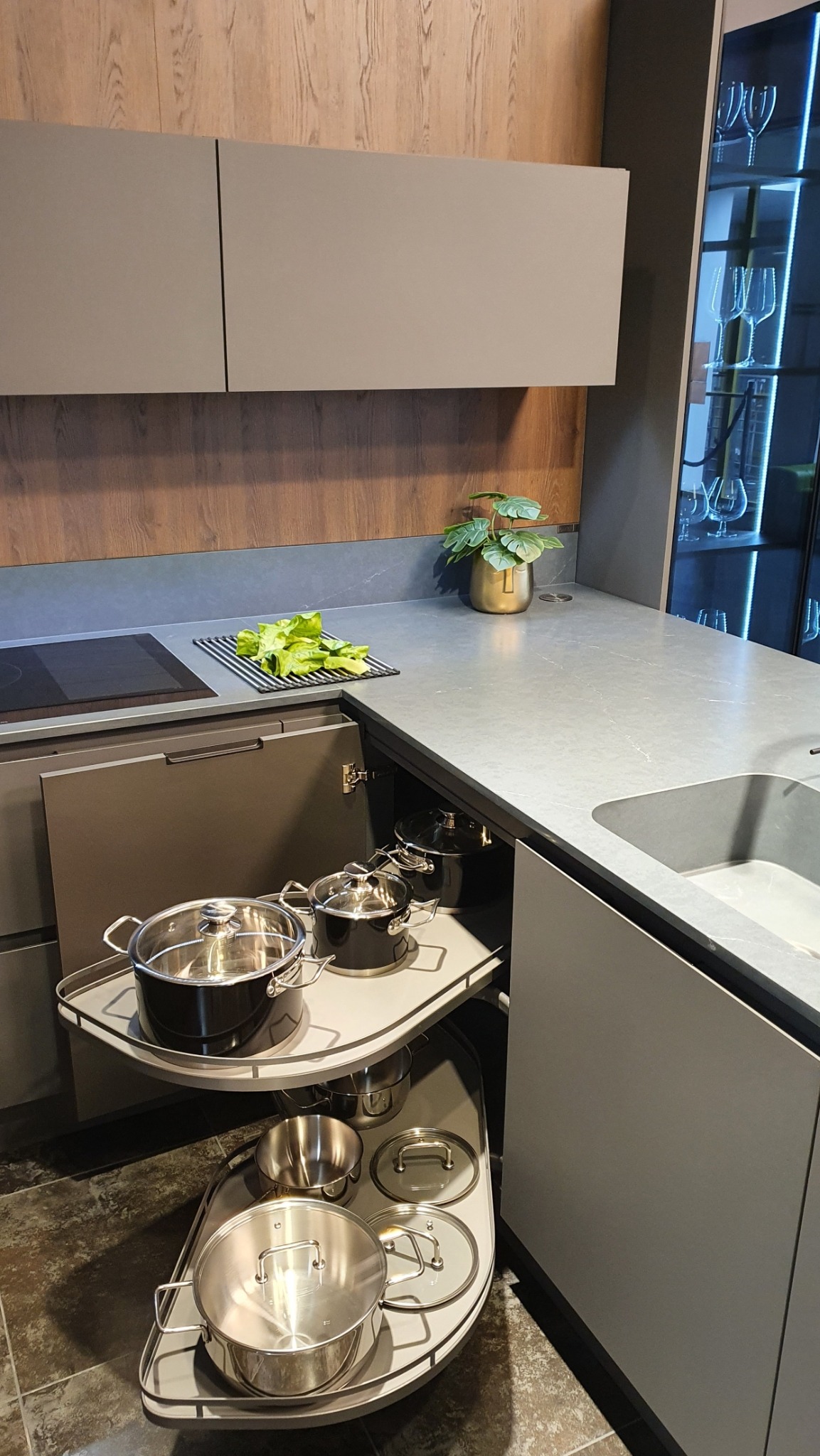 Narożna szafka kuchenna z wysuwanym koszem Le Mans marki Peka, eksponująca garnki. Blat Silestone Charcoal Soapstone i matowe fronty tworzą estetyczną całość.