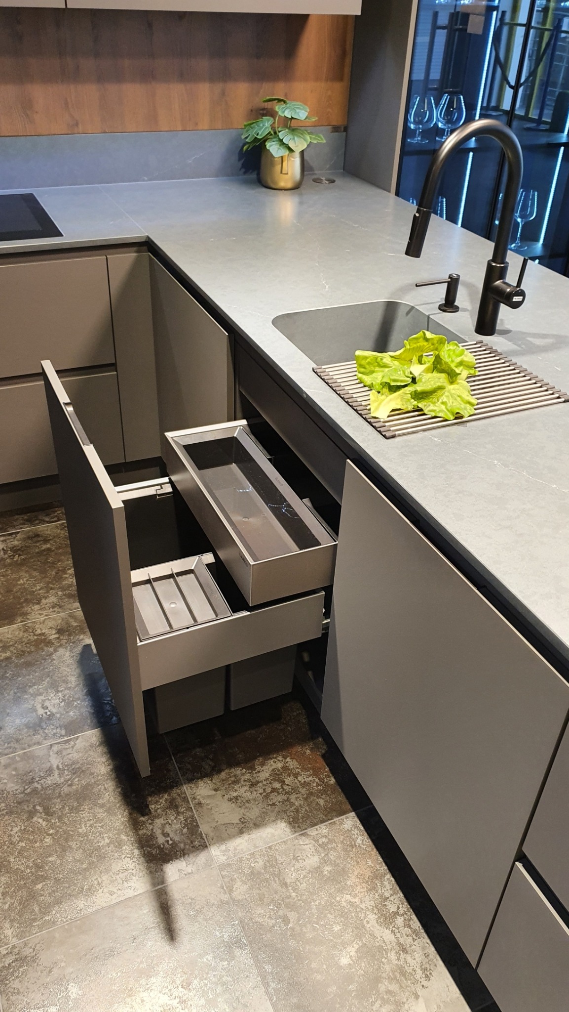Szara kuchnia z blatem Silestone. Otwarta szuflada z sortownikami BLANCO SELECT II 60/4 Orga i organizerem. Na blacie zlew, bateria i sałata.