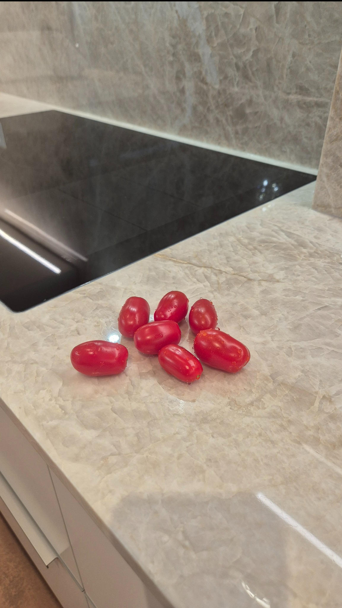 Blat kamienny Taj Mahal z wbudowaną płytą indukcyjną i pomidorkami koktajlowymi. Elegancka, jednolita powierzchnia. Wytrzymałość i nowoczesny design.