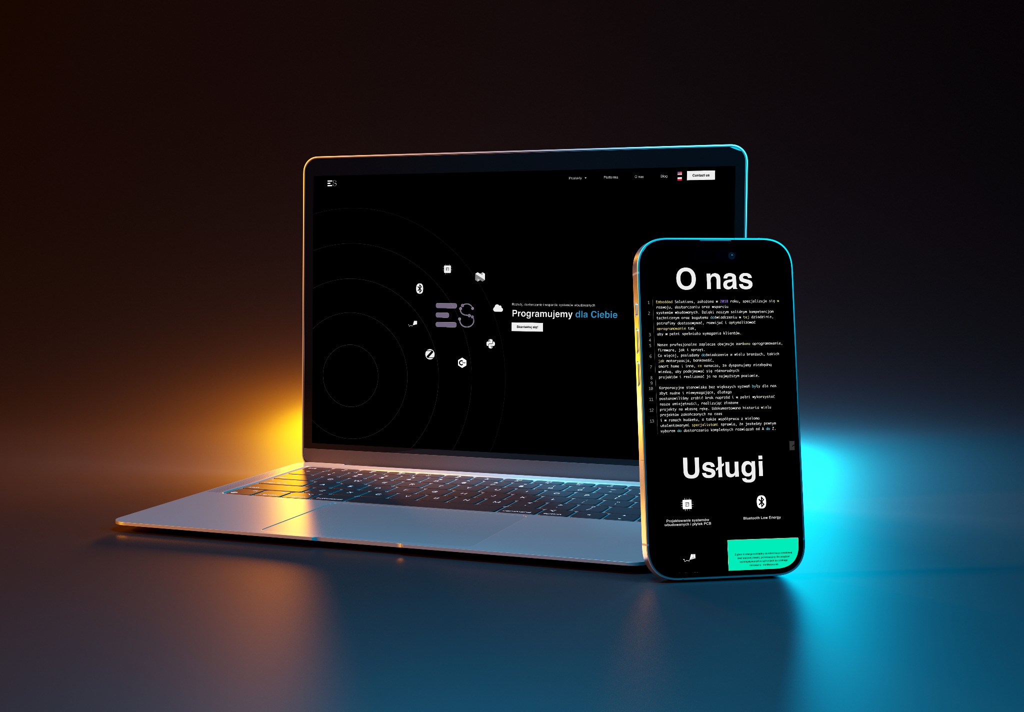 Laptop i smartfon prezentują stronę internetową firmy IT z ofertą programowania systemów wbudowanych. Minimalistyczny design, ciemne tło, podświetlenie.
