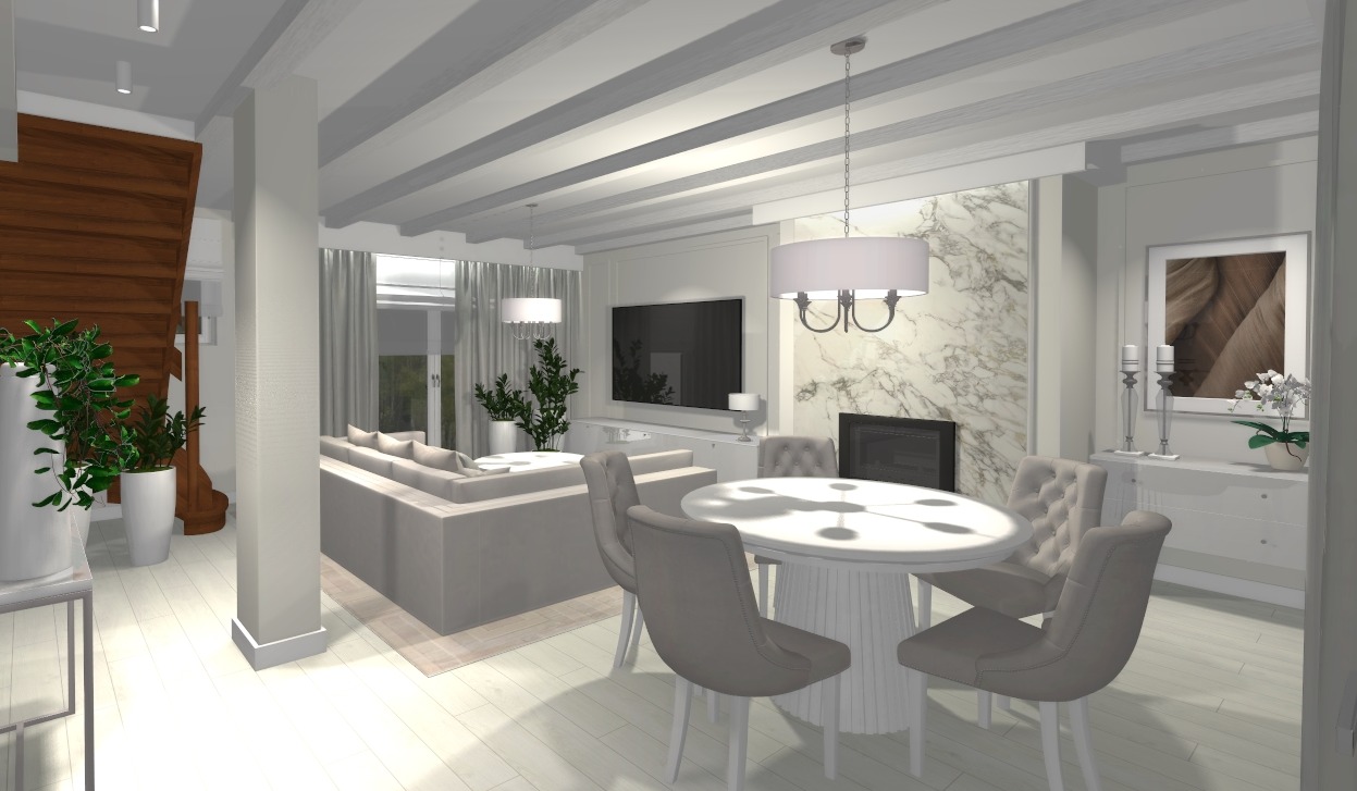 Jasne wnętrze z drewnianymi belkami, sofą, stołem i marmurowym kominkiem. Neutralna kolorystyka i rośliny dodają elegancji. Widok na drewniane schody.