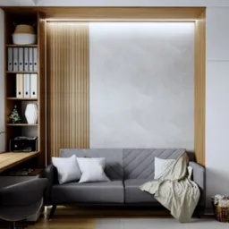 Stylowe wnętrze z szarą sofą, biurkiem pod oknem i zabudową z szafą wnękową. Jasne drewno i biel tworzą nowoczesny klimat. Dekoracje podkreślają charakter wnętrza.