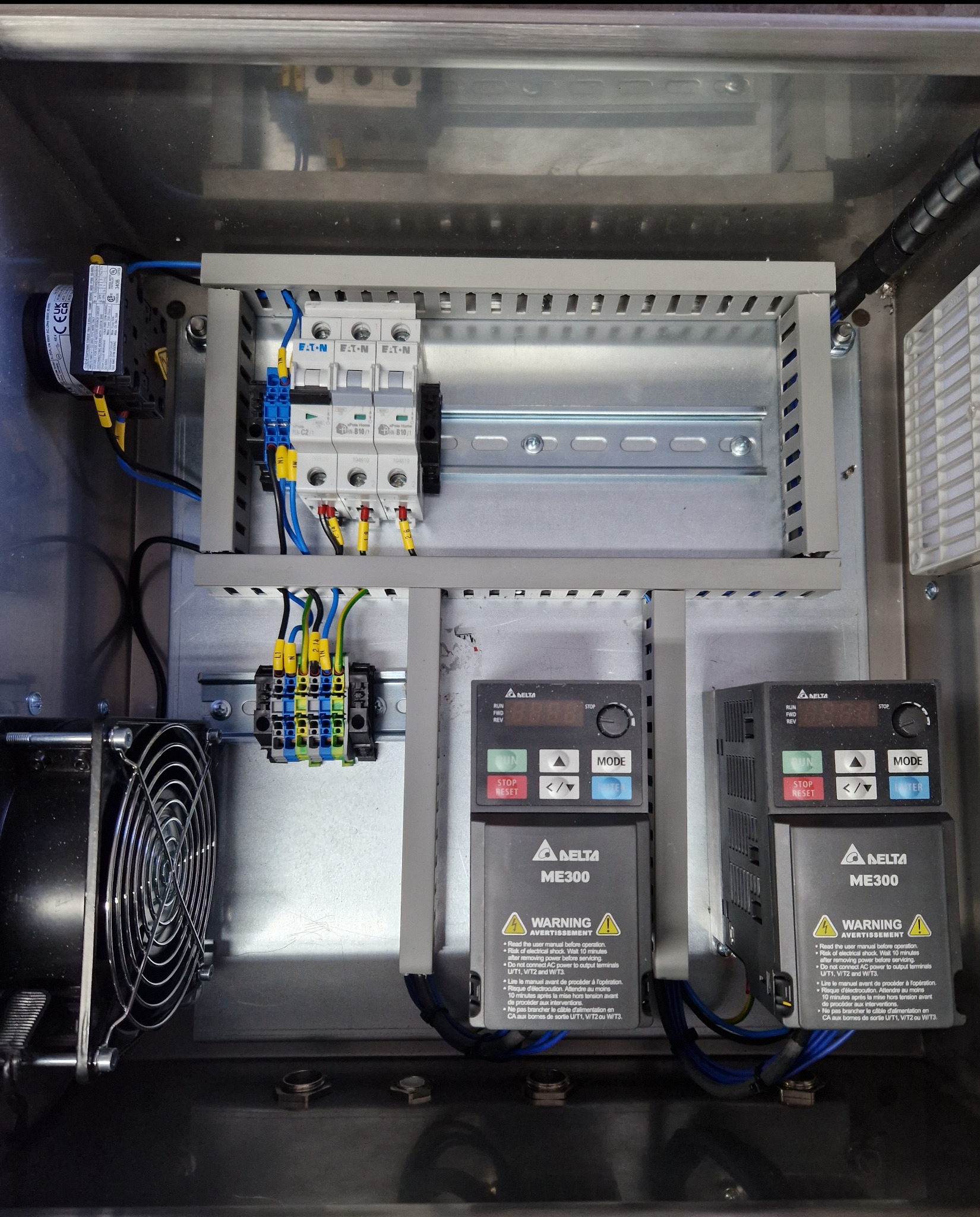 Wnętrze szafy sterowniczej z zamontowanymi elementami elektrycznymi: bezpieczniki EATON, sterowniki Delta ME300, wentylator. Estetyczne ułożenie przewodów.