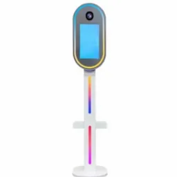 Nowoczesna fotobudka z ekranem dotykowym i podświetleniem LED w kolorach tęczy, na białym tle. Sprzęt do wynajęcia na imprezy i eventy.