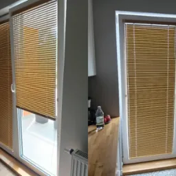 Zestawienie dwóch okien z zamontowanymi, zamkniętymi, poziomymi żaluzjami w kolorze miodowym, tworzącymi jednolitą płaszczyznę. Widoczne detale wnętrza i elementy otoczenia.