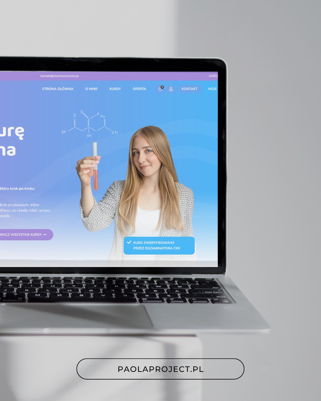 Laptop prezentuje stronę z blondynką trzymającą probówkę, wzór chemiczny i napisy. Niebiesko-fioletowe tło, nowoczesny design. Domena paolaproject.pl.