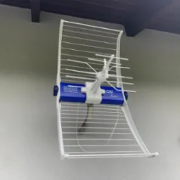 Biała antena telewizyjna typu Yagi-Uda zamontowana na elewacji budynku. Widoczny niebieski element z logo Telmor i napisem 'asr classic'.