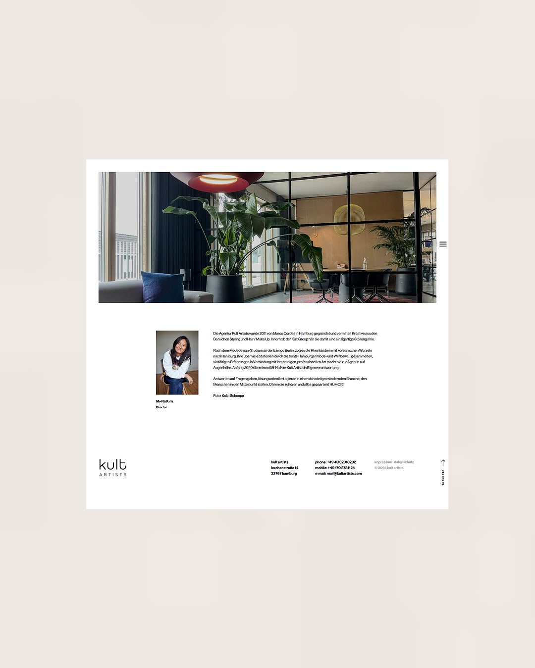 Stylowe biuro agencji Kult Artists z roślinami, szklanymi ścianami i nowoczesnym wystrojem. Widoczny fragment sofy i krzesła konferencyjne.