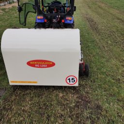 MarKop MARCIN KUCZMIERCZYK - Wertykulacja trawnika w Imielinie. Widok z tyłu na traktor z wertykulatorem RG 1202. Świeżo wertykulowana trawa z widocznymi śladami pracy urządzenia.