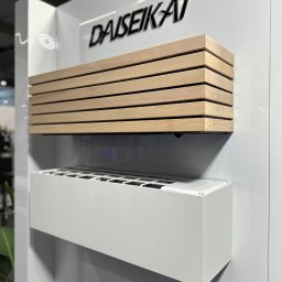 PSD SPÓŁKA Z OGRANICZONĄ ODPOWIEDZIALNOŚCIĄ - Nowoczesna klimatyzacja DAISEIKAI z drewnianą obudową, zamontowana na białej ścianie. Minimalistyczny design, widoczne detale wykończenia.