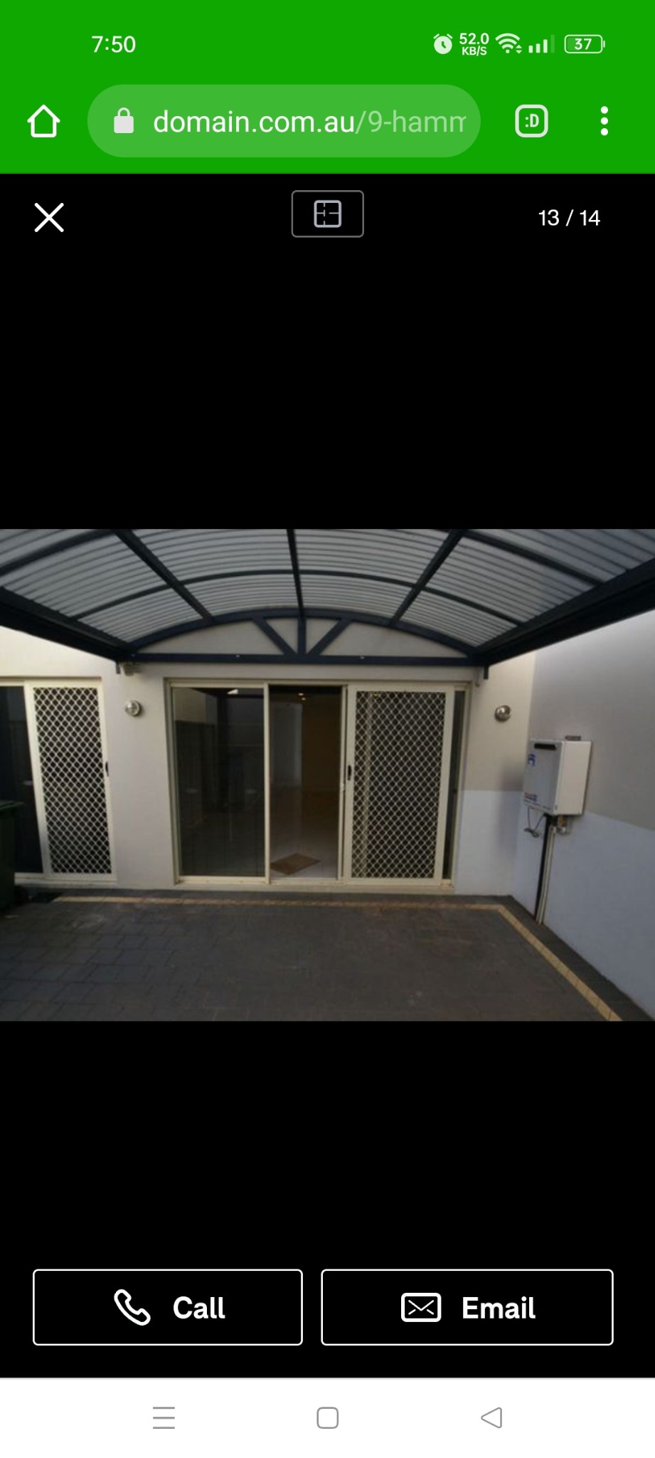 Zadaszony taras z przesuwnymi drzwiami i zabudowanym licznikiem, wyłożony kostką brukową. Widok z zewnątrz na budynek.