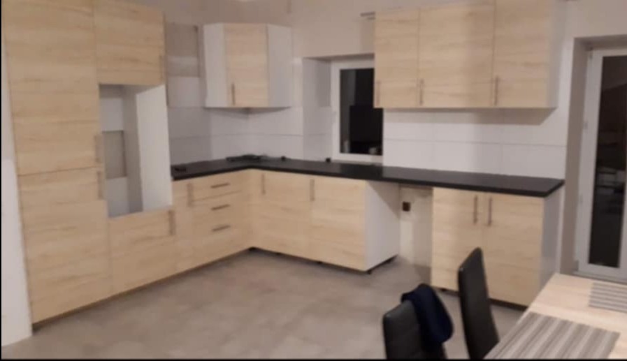 Realizacja kuchni z ułożonymi płytkami na podłodze oraz między szafkami