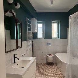 Solid.RemontPlus - Nowoczesna łazienka po remoncie: białe płytki, ciemnozielone ściany, wzorzysta podłoga, umywalka z szafką, wanna i okna. Elementy wykończeniowe.