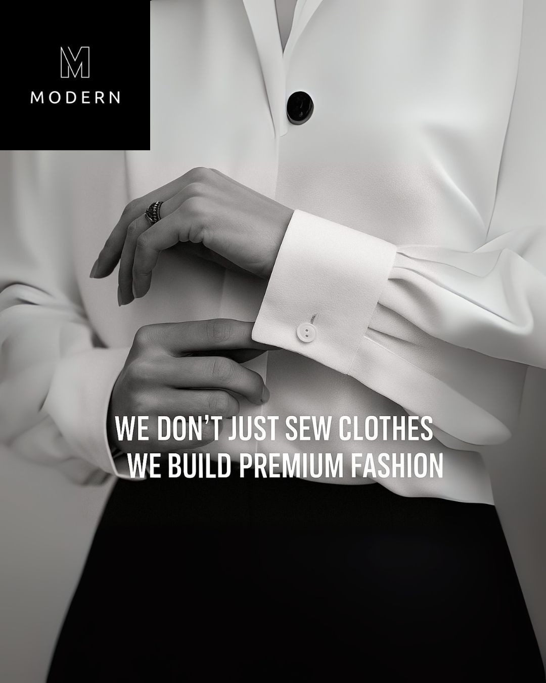 Dłonie zapinające mankiet białej bluzki z napisem 'We don't just sew clothes, we build premium fashion'. Elegancki, nowoczesny design i dbałość o detale.