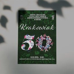 NOKO-CREATE PATRYK WOJEWODZIC - Plakat jubileuszowego koncertu zespołu tańca ludowego Krakowiak, z motywami kwiatowymi i datą wydarzenia 16.05.2023. Ciemnozielone tło, białe napisy.