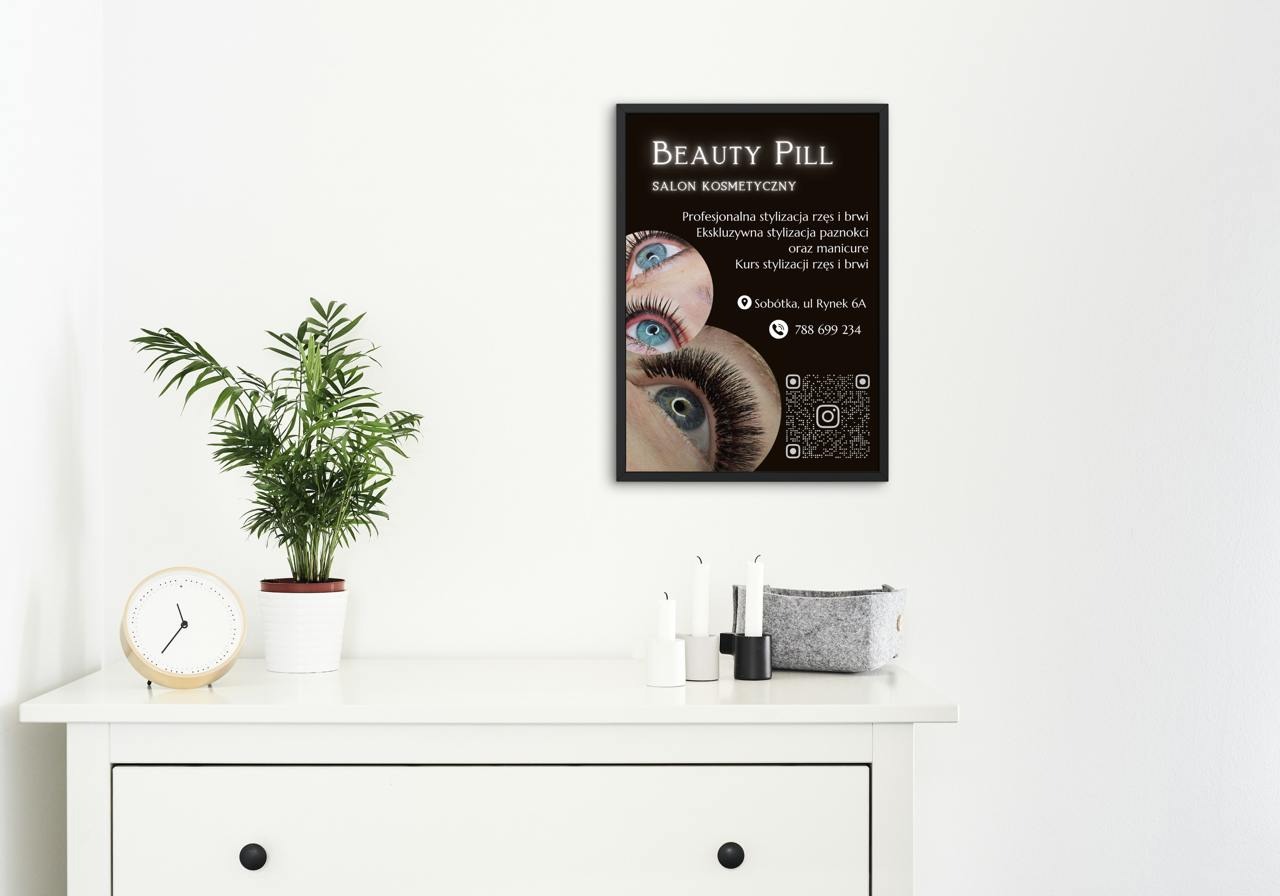 Plakat salonu kosmetycznego 'Beauty Pill' z ofertą stylizacji rzęs, brwi i paznokci, umieszczony w minimalistycznym wnętrzu na białej komodzie.