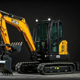 Żółto-czarna minikoparka JCB na gładkim tle, z wyraźnie widocznymi detalami kabiny, gąsienic i ramienia z łyżką. Oświetlenie studyjne podkreśla kształt maszyny.