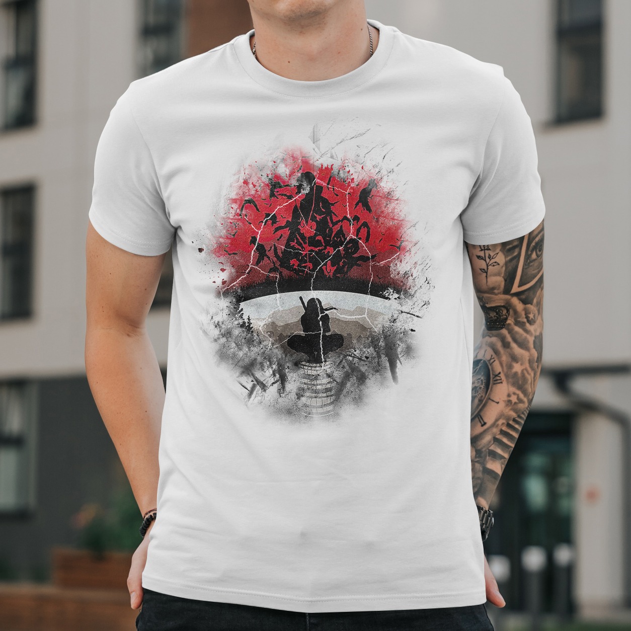 Biała koszulka z artystycznym nadrukiem w odcieniach czerwieni i szarości, przedstawiającym motyw inspirowany kulturą japońską. Widoczny fragment tatuażu na ramieniu modela.