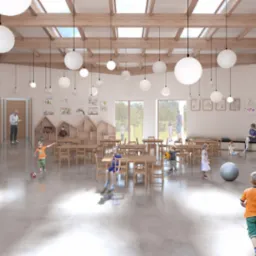 Wnętrze przedszkola z drewnianą konstrukcją dachu i wiszącymi kulistymi lampami. Dzieci bawią się w przestronnej sali z drewnianymi meblami i dekoracjami na ścianach.