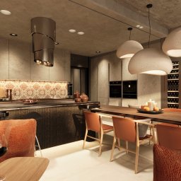 Pindearte - Nowoczesna kuchnia z wyspą, pomarańczowymi akcentami i oświetleniem. Nad blatem wisi designerski okap. W tle widać zabudowę z piekarnikami i regałem na wino.