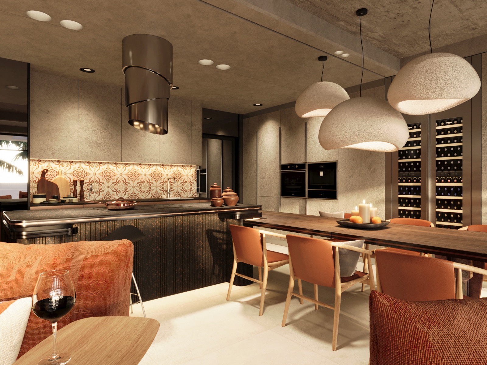 Nowoczesna kuchnia z wyspą, pomarańczowymi akcentami i oświetleniem. Nad blatem wisi designerski okap. W tle widać zabudowę z piekarnikami i regałem na wino.