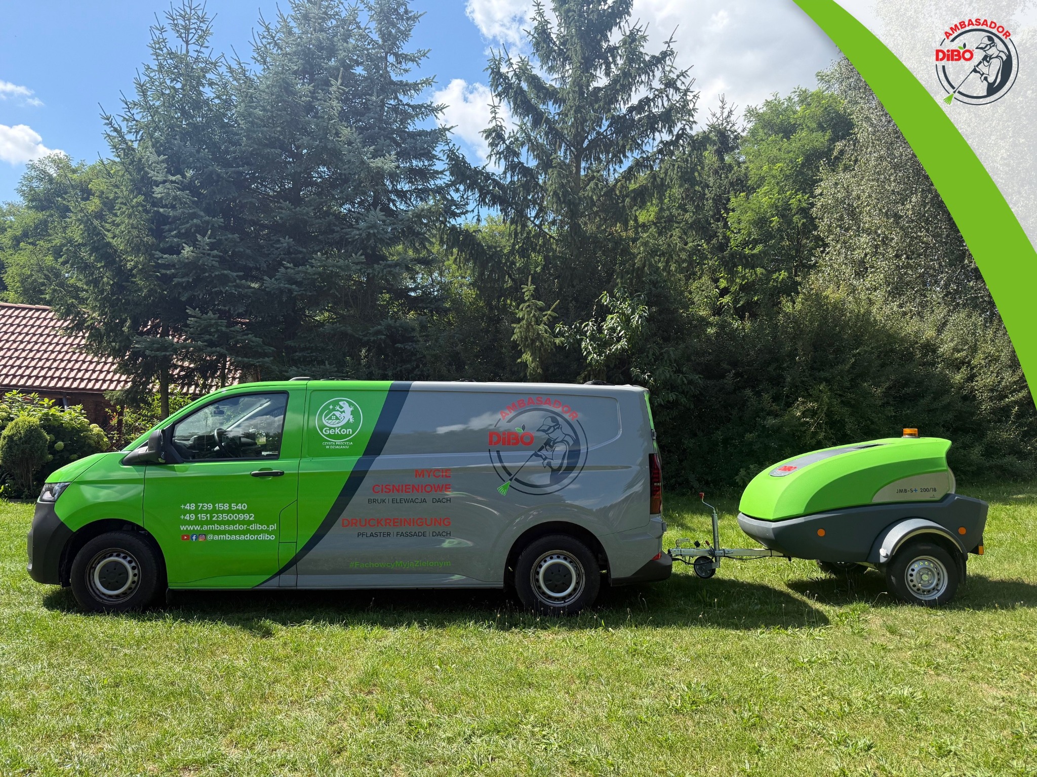 Zielono-szary van z przyczepą Dibo na trawie, z logo firmy oferującej mycie ciśnieniowe bruku, elewacji i dachów. W tle drzewa i fragment budynku.