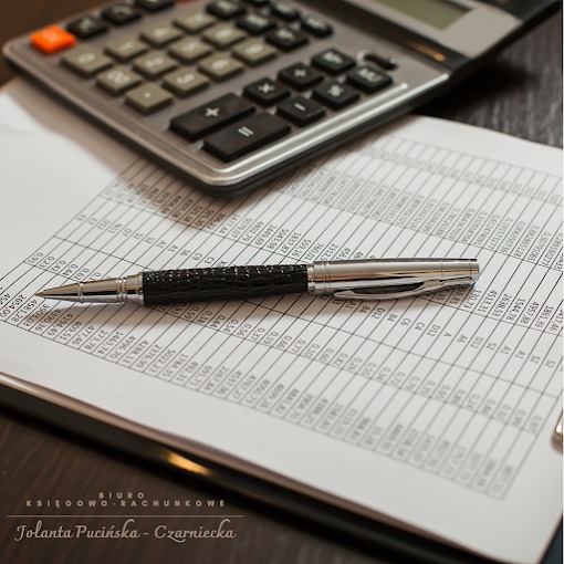 Kalkulator, długopis i arkusz kalkulacyjny na biurku. Narzędzia pracy księgowego w stonowanej kolorystyce.