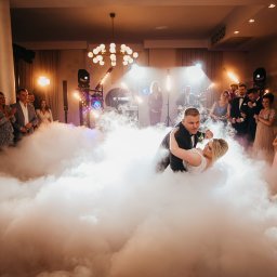 OLSZEWSKI - DJ i Konferansjer - Pierwszy taniec pary młodej w Otwocku, otoczonej dymem scenicznym i oświetleniem, z zespołem muzycznym w tle i gośćmi weselnymi.