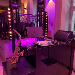 OLSZEWSKI - DJ i Konferansjer - Scena z saksofonem, sprzętem DJ-skim i oświetleniem w fioletowej tonacji. Laptop na statywie. Gotowość do występu muzycznego.