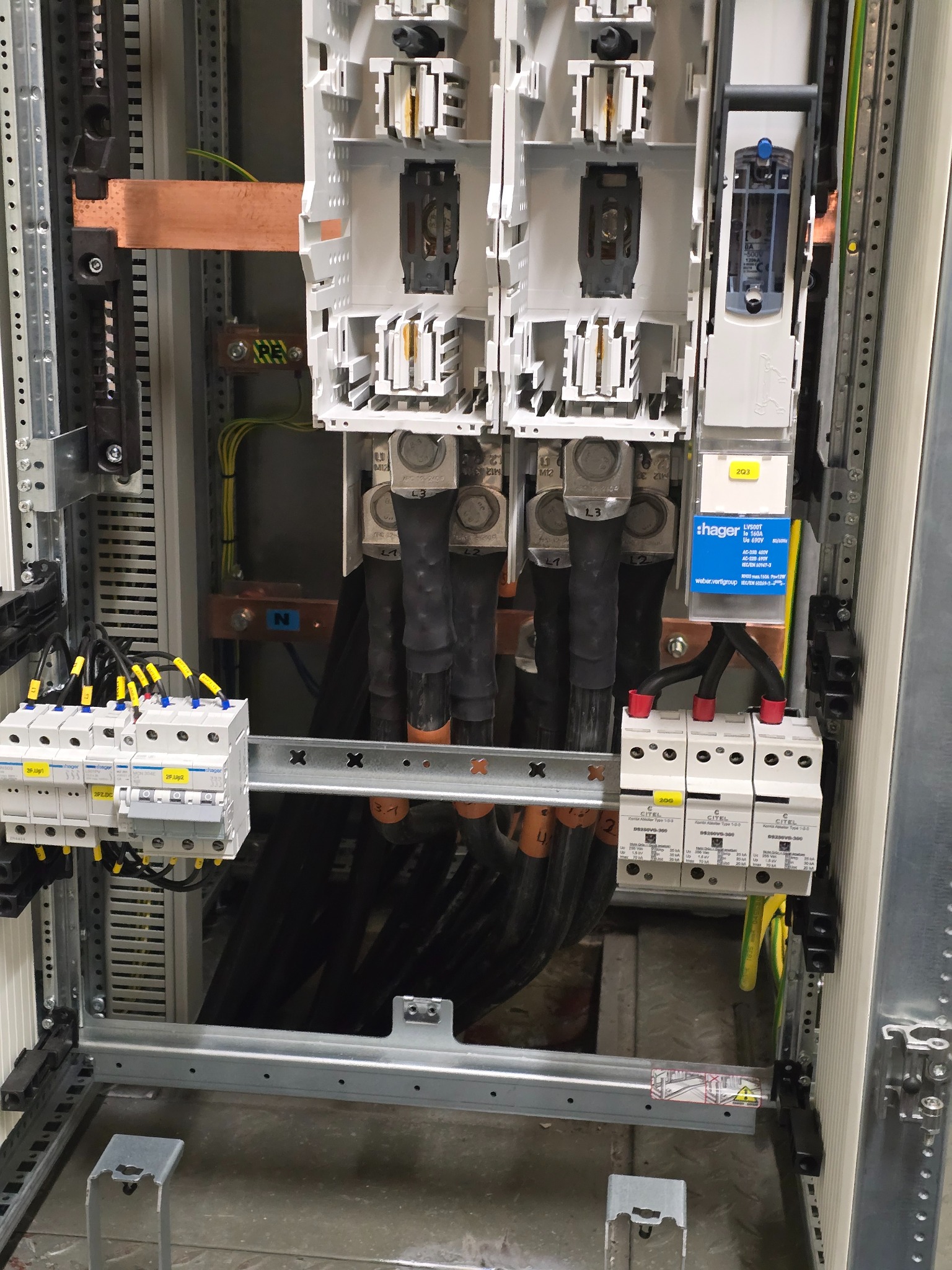 Rozdzielnia elektryczna z bezpiecznikami, przewodami i elementami montażowymi. Widoczne szczegóły instalacji, kable i oznaczenia. Profesjonalny montaż i dbałość o detale.