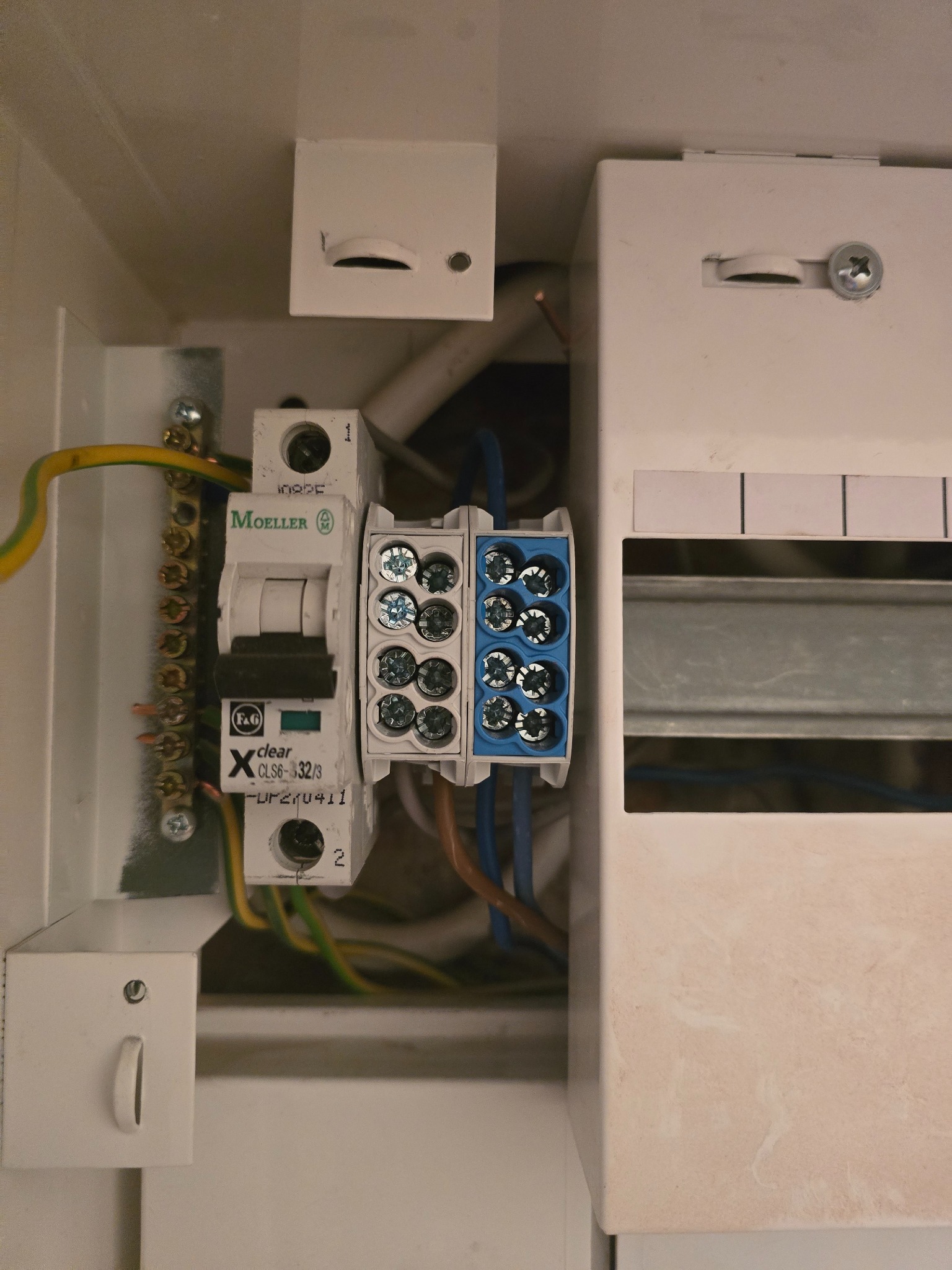 Szczegółowe ujęcie skrzynki elektrycznej z zamontowanym wyłącznikiem Moeller i złączkami, widoczne przewody. Element instalacji elektrycznej w obudowie.