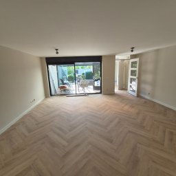 KADET STYL I PRECYZJA - Jasne, przestronne wnętrze z parkietem w jodełkę i otwartym wyjściem na taras. Świeżo wykończone ściany, nowoczesne oświetlenie.