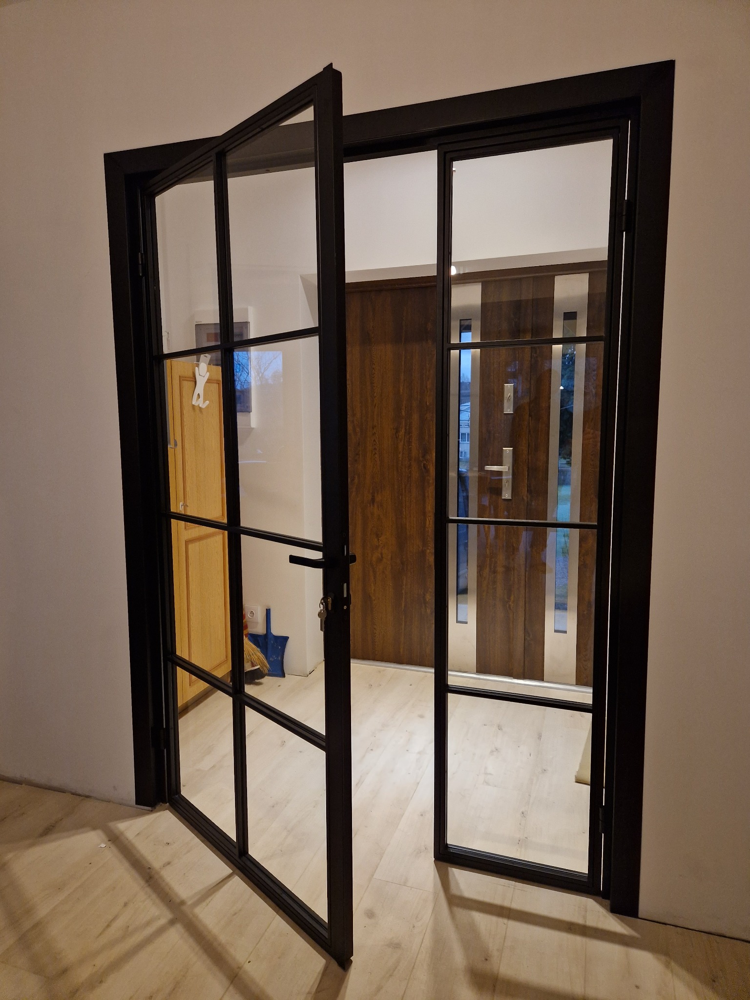 Loftowe drzwi szklane z czarną ramą, częściowo otwarte, widok na wnętrze. Realizacja z Zaleszan.