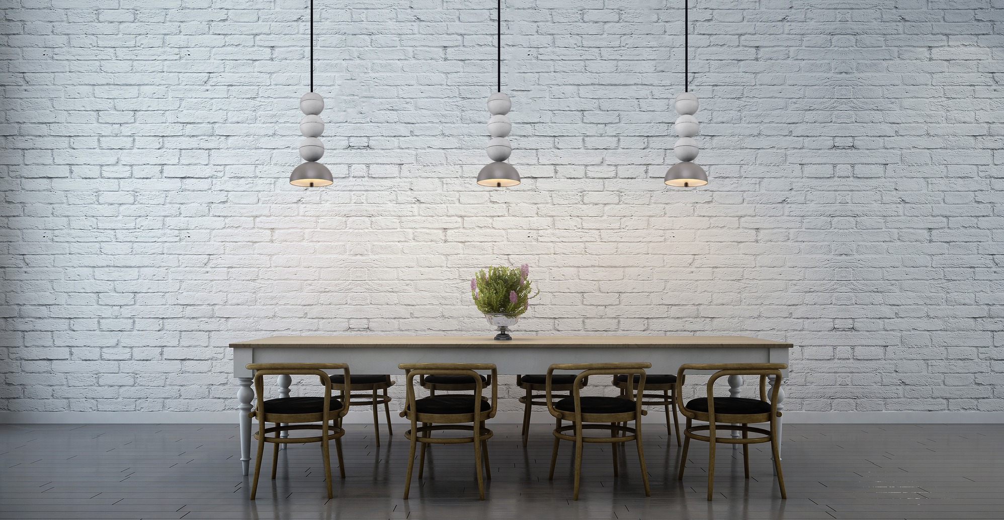 Jadalnia z białej cegły z trzema nowoczesnymi lampami wiszącymi nad stołem i krzesłami. Na stole wazon z kwiatami. Minimalistyczny design.