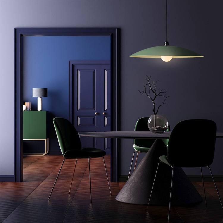 Stylowa jadalnia z okrągłym stołem, zielonymi krzesłami i wiszącą lampą w odcieniach zieleni. W tle widoczne drzwi i komoda z lampką.