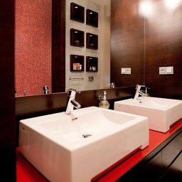 Wysoka łazienka w szczecińskiej kamienicy z czerwoną mozaiką i drewnem wenge, w realizacji pod klucz architekt i projektant wnętrz Anny Buczny. Projektantka większość swoich projektów realizuje pod klucz.